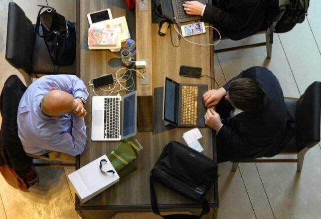 Three men sat working together