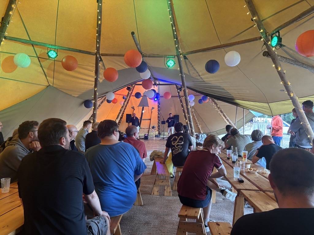 People singing karaoke inside a tent
